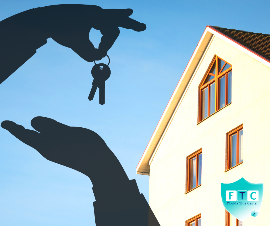 shadow of a hand with keys and a house